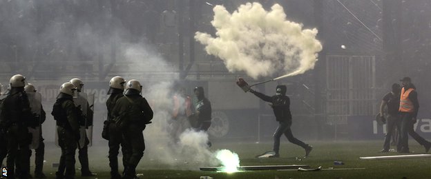 Fan throws fire extinguisher as the match between Panathinaikos and Olympiakos is called off 