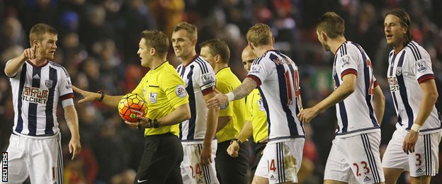 West Brom players remonstrate with referee Craig Pawson at half time